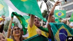 Supporters of Brazilian presidential candidate Jair Bolsonaro cheer as they gather outside his residence in Rio de Janeiro, Brazil, Sunday, Oct. 28, 2018, during the country's presidential runoff election. 