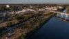 Los vehículos de las fuerzas del orden se alinean a lo largo de la frontera entre Estados Unidos y México en Ciudad Acuña, como se ve en esta fotografía aérea tomada desde Del Rio, Texas, Estados Unidos el 23 de septiembre de 2021.