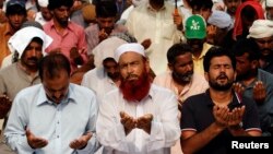 Supporters of Tahir ul-Qadri, Sufi cleric and leader of political party Pakistan Awami Tehreek, offer prayers in front of the Parliament House during the Revolution March in Islamabad, Aug. 22, 2014.