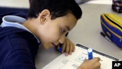 FILE - A student, who speaks Spanish at home, works on a lesson during an English class at Coral Way K-8 Center in Miami, Florida.