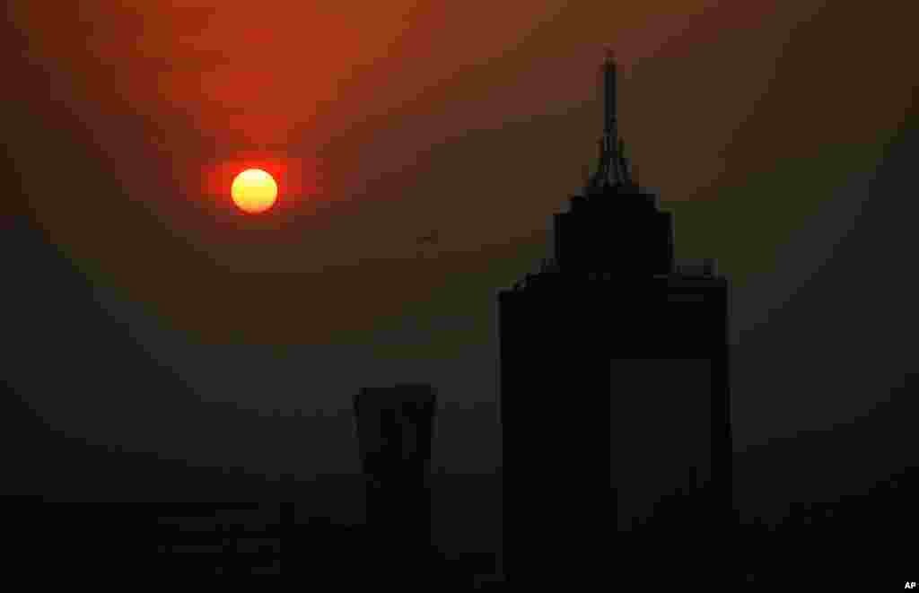 طلوع خورشید پشت ساختمان مرکز تجارت جهانی در &#171;روز زمین&#187; در صبح دودآلود شهر مکزیکوسیتی، مکزیک