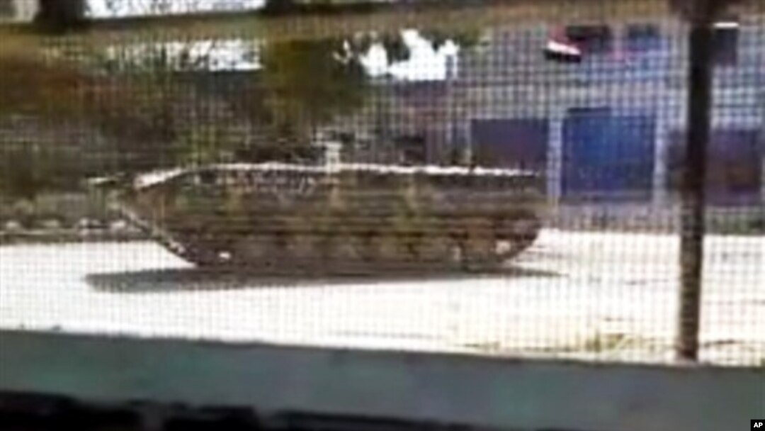 Foto yang diambil dari video amatir ini dirilis oleh Jaringan Berita Shaam, yang menunjukkan kendaraan lapis baja tentara Suriah yang masih berjaga di Idlib, Suriah (12/4).