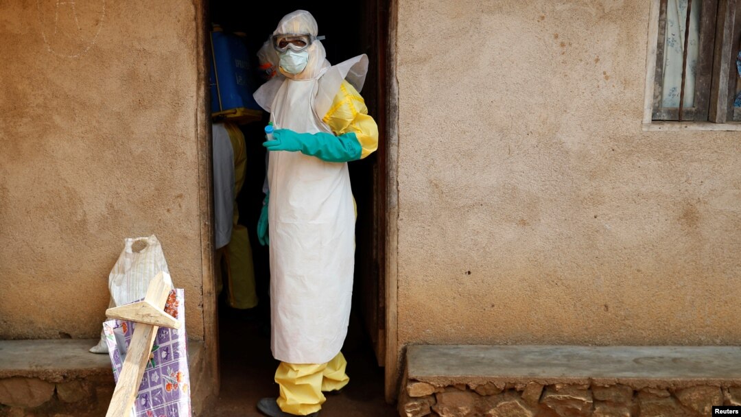 Health care workers enter a house where a baby suspected of dying of Ebola is, during the baby's funeral in Beni, North Kivu province, Democratic Republic of the Congo, Dec. 18, 2018. 
