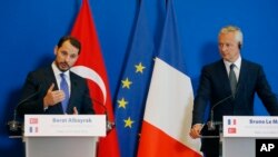 FILE - Turkey's Treasury and Finance Minister Berat Albayrak, left, and France's Finance Minister Bruno Le Maire make declarations to the media at the ministry in Paris, France, Aug. 27, 2018.