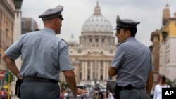 FILE - Italian financial police officers talk to each other in front of St. Peter's Square at the Vatican, Sept. 2010.