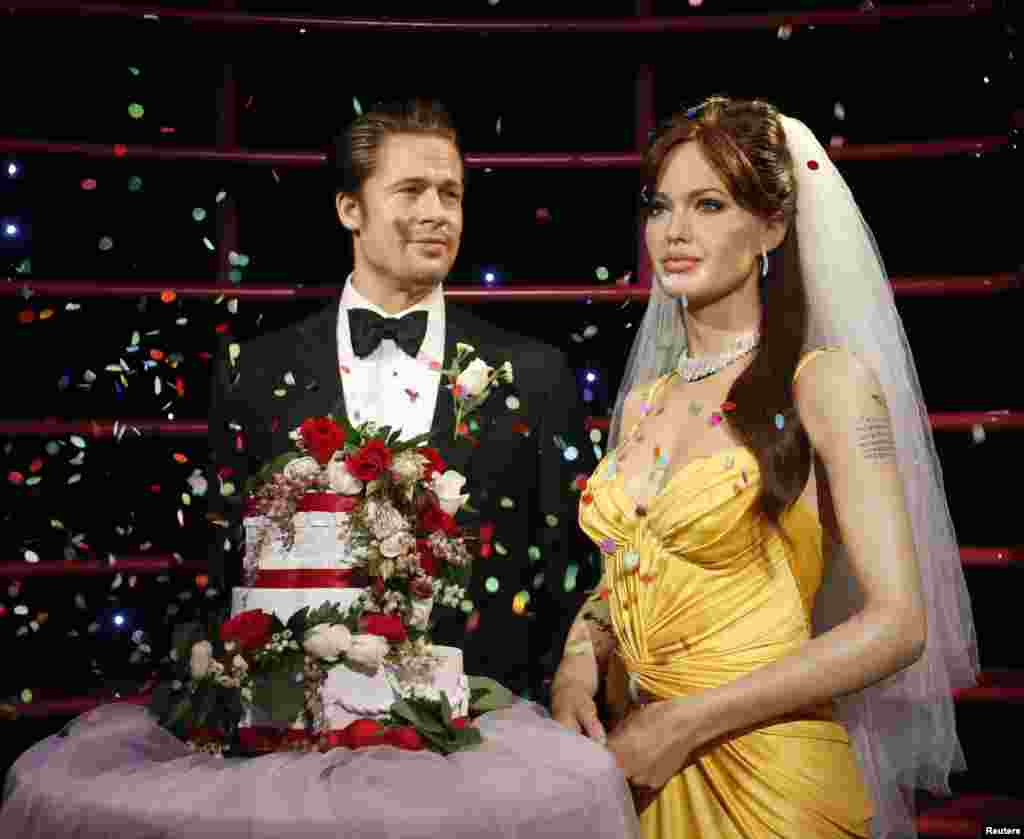Tượng sáp các diễn viên Brad Pitt và Angelina Jolie được tung hoa giấy lên người sau khi được giới thiệu với một chiếc bánh cưới trong lễ cưới gần đây của họ, tại bảo tàng tượng sáp Madame Tussauds ở Sydney, Australia.