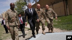 FILE - U.S. Defense Secretary Jim Mattis, third right, walks with U.S. Army Command Sergeant Major David Clark, left, and General Christopher Haas, second right, as he arrives to the Resolute Support headquarters in Kabul, Afghanistan, April 24, 2017. 