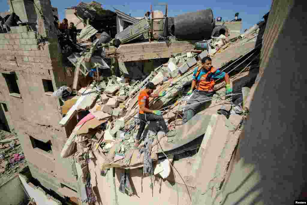 Rescuers work to recover the body of a Palestinian girl from under the rubble of a house hit in an Israeli strike, amid the Israel-Hamas conflict, in Gaza City.