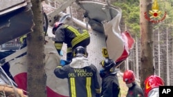 Rescuers work by the wreckage of a cable car after it collapsed near the summit of the Stresa-Mottarone line in the Piedmont region, northern Italy, May 23, 2021.