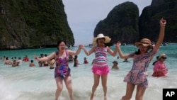 Tourists jump in the waves on Maya Bay, Phi Phi Leh island in Krabi province, Thailand, Thursday, May 31, 2018. (AP Photo/Sakchai Lalit)