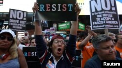 Masyarakat memprotes pengumuman Presiden Donald Trump bahwa dia berencana menerapkan kembali pelarangan bagi kaum transgender untuk berdinas di militer dalam kapasitas apapun di militer Amerika, di Times Square, New York City, New York, 26 Juli 2017. 