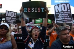 FILE - People protest U.S. President Donald Trump's announcement that he plans to reinstate a ban on transgender individuals from serving in any capacity in the U.S. military, in Times Square, in New York City, New York, July 26, 2017.