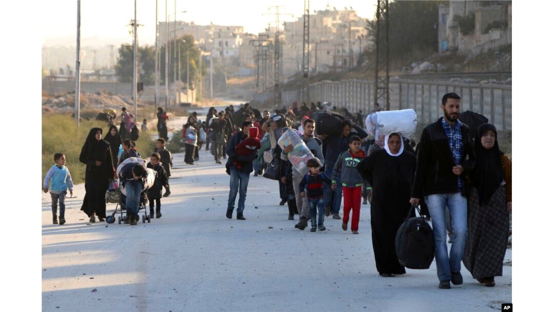 This Nov. 27, 2016 photo provided by the Rumaf, a Syrian Kurdish activist group, shows people fleeing rebel-held eastern neighborhoods of Aleppo into the Sheikh Maqsoud area that is controlled by Kurdish fighters.