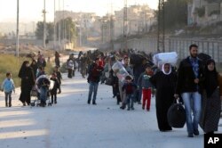 This Nov. 27, 2016 photo provided by the Rumaf, a Syrian Kurdish activist group, shows people fleeing rebel-held eastern neighborhoods of Aleppo into the Sheikh Maqsoud area that is controlled by Kurdish fighters.