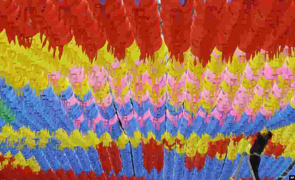 A worker adjusts lanterns for the upcoming celebration of Buddha&#39;s birthday on May 14 at the Bongeun temple in Seoul, South Korea.