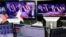 FILE - An employee of a foreign exchange trading company looks at monitors showing U.S. President elect Donald Trump speaking on TV news in Tokyo, Japan, Nov. 9, 2016. 