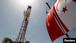 Turkish and Turkish Cypriot flags wave beside a offshore drilling tower near Famagusta, Cyprus, April 26, 2012.