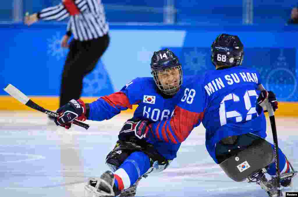 Seung Hwan Jung dari Korea merayakan dengan rekannya, Min Su Han, setelah meraih skor 2-0 dalam pertandingan awal Hoki Es Grup B antara Korea dan Jepang di Gangneung Hockey Centre, Paralimpiade Musim Dingin, Pyeongchang, Korea Selatan, 10 Maret 2018.