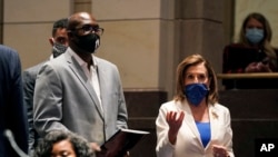 FILE - Philonise Floyd, a brother of George Floyd, and House Speaker Nancy Pelosi arrive for a House Judiciary Committee hearing on proposed changes to police practices and accountability, on Capitol Hill, June 10, 2020, in Washington.