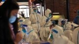 This photo taken on October 31, 2021 shows medical personnel preparing to test visitors for the Covid-19 coronavirus at Disneyland in Shanghai after a single coronavirus case was detected at the park on the weekend. 