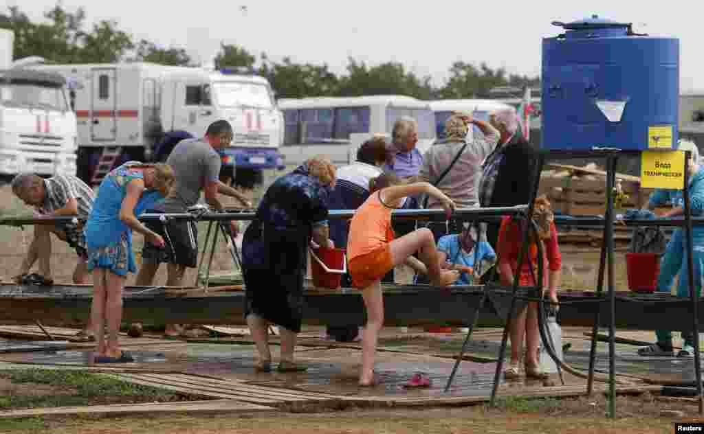 People clean themselves at a refugee camp set up for Ukrainians in Russia&#39;s Rostov region near the Russia-Ukraine border, Aug. 18, 2014.