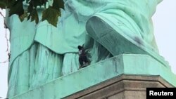 A protester is seen on the Statue of Liberty in New York, July 4, 2018, in this picture obtained from social media. (Danny Owens/via Reuters)
