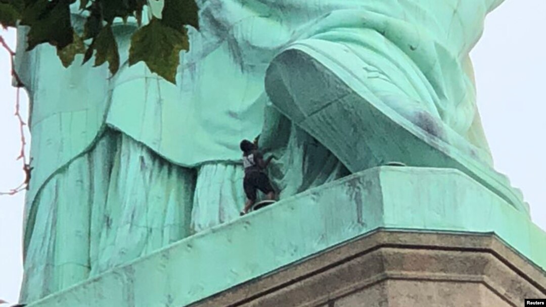 A protester is seen on the Statue of Liberty in New York, July 4, 2018, in this picture obtained from social media. (Danny Owens/via Reuters)