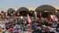 FILE - Displaced Iraqis from the Yazidi community look for clothes to wear among items provided by a charity organization at the Nowruz camp, in Derike, Syria, Aug. 12, 2014.