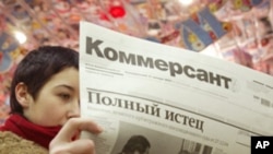 A Muscovite reads the latest issue of Kommersant with most of its pages blank at a metro station in central Moscow. (File Photo)