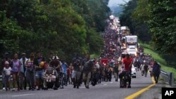 FILE - Migrants walk along the highway toward the municipality of Escuintla, Chiapas state, Mexico, Oct. 28, 2021, as they continue their journey toward the northern states of Mexico and the US border. 