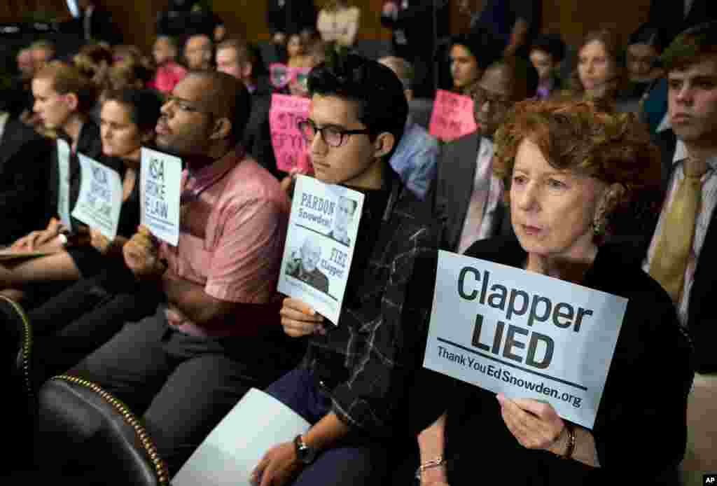 Protesters hold signs during a Senate Judiciary Committee oversight hearing on Capitol Hill in Washington, D.C., on the Foreign Intelligence Surveillance Act with National Security Agency Director Gen. Keith Alexander and National Security Agency Director Gen. Keith Alexander. U.S. intelligence officials say the government shutdown is seriously damaging the intelligence community’s ability to guard against threats.