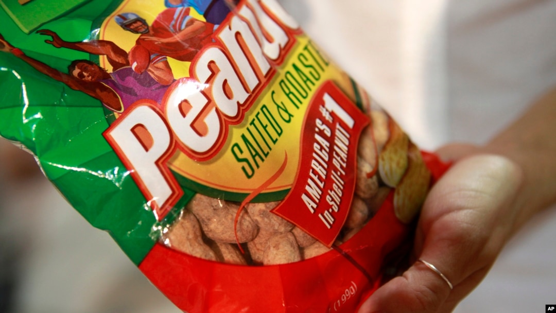 FILE - A fan at a Washington Nationals baseball game holds a bag of peanuts, at Nationals Park in Washington, D.C.