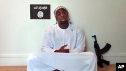 FILE - Amedy Coulibaly, killed by police after taking hostages at a Paris kosher market, appears in a video posted online by militants two days later, on Jan. 11, 2015. Spanish police have arrested a man suspected of supplying Coulibaly with a gun.