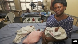 Mabel Ighedosa, 30, sits with her newborn triplets Isaac, Treasure and Samuel in a ward of the Lagos Island Maternity Hospital in Lagos, Nigeria, October 31, 2011.