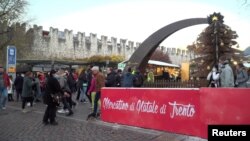 Pengunjung berbelanja di kios-kios pasar Natal Trento yang dibuka akhir pekan lalu, di Trento, Italia, meskipun ada kekhawatiran meningkatnya kasus COVID-19 20 November 2021. ( REUTERS/Matteo Berlenga)