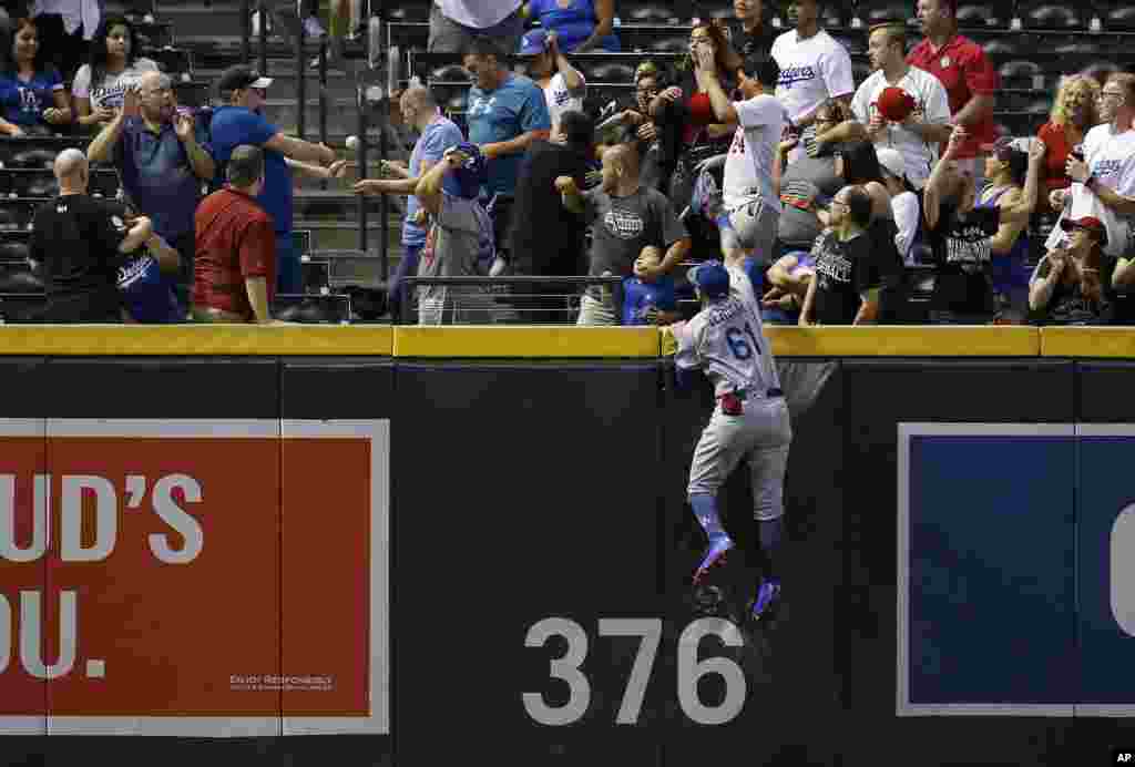 Los Angeles Dodgers left fielder Alex Verdugo (61) jumps in vain for home run hit by Arizona Diamondbacks&#39; A.J. Pollock during the ninth inning of a baseball game, Sept. 24, 2018, in Phoenix, Arizona.