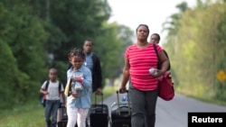 Một gia đình từ Haiti băng qua biên giới Mỹ-Canada từ Champlain, New York, để vào Canada xin quy chế tị nạn