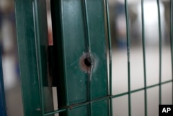 This April 12, 2017, photo shows a bullet hole on the front gate of a school in Acari, Rio de Janeiro, Brazil, where 13-year-old Maria Eduarda Conceicao was shot and killed when she was caught in the crossfire of a lengthy shootout between police and gangsters.