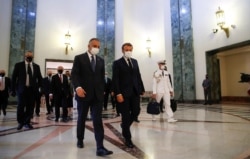 FILE - French President Emmanuel Macron, center right, and Iraqi Prime Minister Mustafa al-Kadhimi, head for a meeting in Baghdad, Sept. 2, 2020.