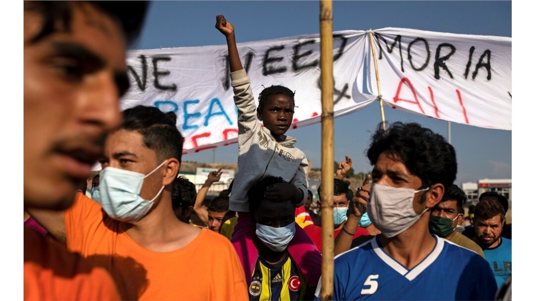 Refugees and migrants from the destroyed Moria camp protest after the news about the creation of a new temporary camp, on the island of Lesbos, Greece, Sept. 12, 2020.