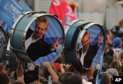 Partidarios del candidato del Partido "Frente de Todos" Alberto Fernández sostienen tambores decorados con su imágen un mitin en Rosario, Argentina, el miércoles, 7 de agosto, de 2019.