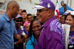 FILE - Then-Surinamese President Desi Bouterse greets supporters as he leaves a polling station, after casting his ballot in the general election, in Paramaribo, Suriname, on May 25, 2015.