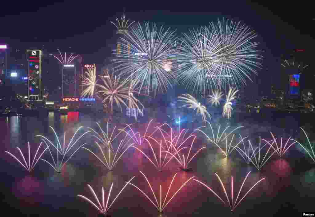 Kembang api menghiasi langit di atas Pelabuhan Victoria dan Hong Kong Convention and Exhibition Center untuk merayakan tahun baru 2014. (Reuters/Tyrone Siu)