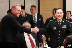 Acting U.S. Secretary of Defense Patrick Shanahan, left, shakes hands with Chinese Minister of National Defense Gen. Wei Fenghe on the sidelines of the 18th International Institute for Strategic Studies Shangri-la Dialogue, Singapore, June 1, 2019.