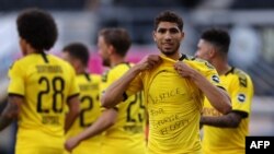 Bek Dortmund asal Maroko, Achraf Hakimi, memperlihatkan kaus "Keadilan untuk George Floyd" setelah mencetak gol keempat bagi timnya dalam pertandingan sepak bola Bundesliga divisi satu Jerman SC Paderborn 07 dan Borussia Dortmund di Benteler Arena di Paderborn, 31 Mei 2020.
