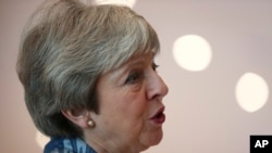 British Prime Minister Theresa May speaks with the media as she arrives for an EU-Arab summit at the Sharm El Sheikh convention center in Sharm El Sheikh, Egypt, Sunday, Feb. 24, 2019. 