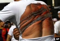 A Lebanese Shi'ite man strikes his back with knives to show his grief during Ashura rituals in the southern market town of Nabatieh, Oct. 12, 2016.