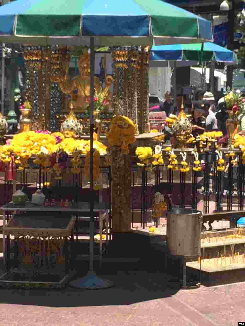 Bunga-bunga diletakkan di Kuil Erawan di Bangkok (19/8). (VOA/Steve Herman)