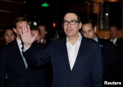 FILE - U.S. Treasury Secretary Steven Mnuchin, a member of the U.S. trade delegation to China, waves to the media upon his arrival at a hotel in Beijing, China, Feb. 12, 2019.