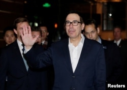 U.S. Treasury Secretary Steven Mnuchin, a member of the U.S. trade delegation to China, waves to the media upon his arrival at a hotel in Beijing, China, Feb. 12, 2019.